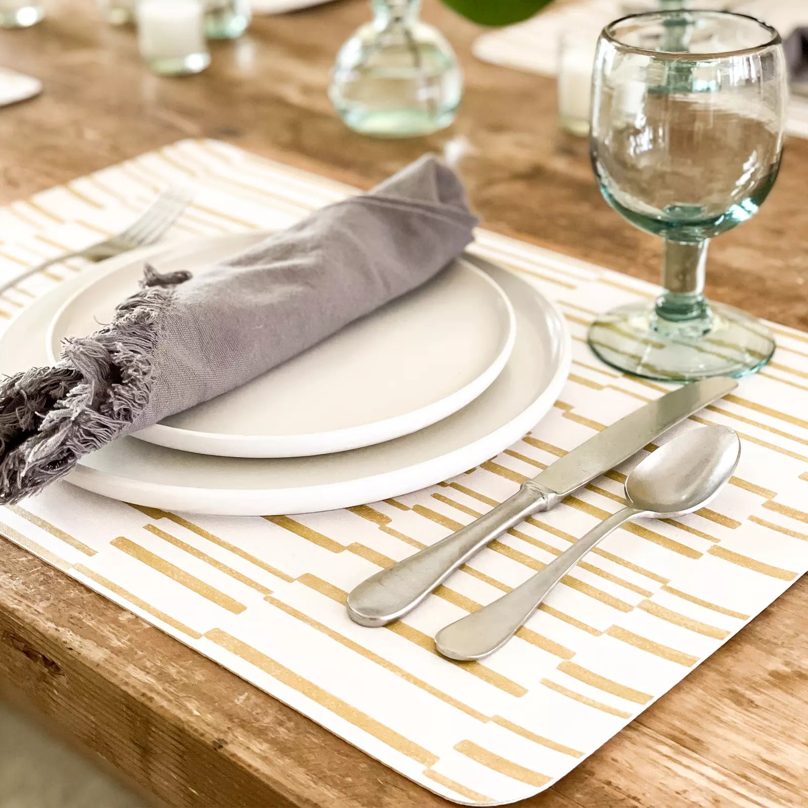 Nara Ochre Yellow Striped place mat at table setting with plate, napkin and  silverware