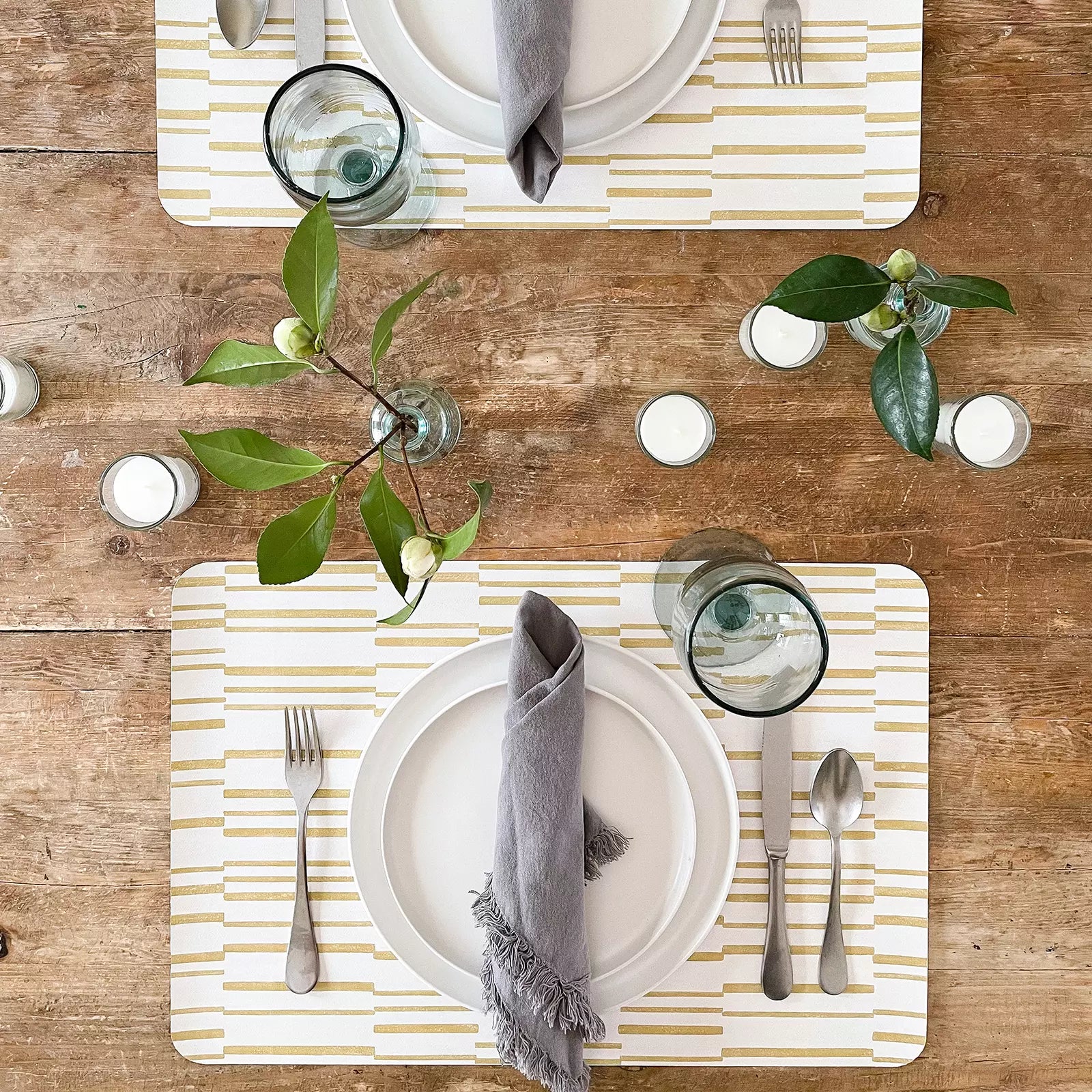 Nara Ochre Yellow Striped place mat at table setting with plate, napkin and silverware pictured from above