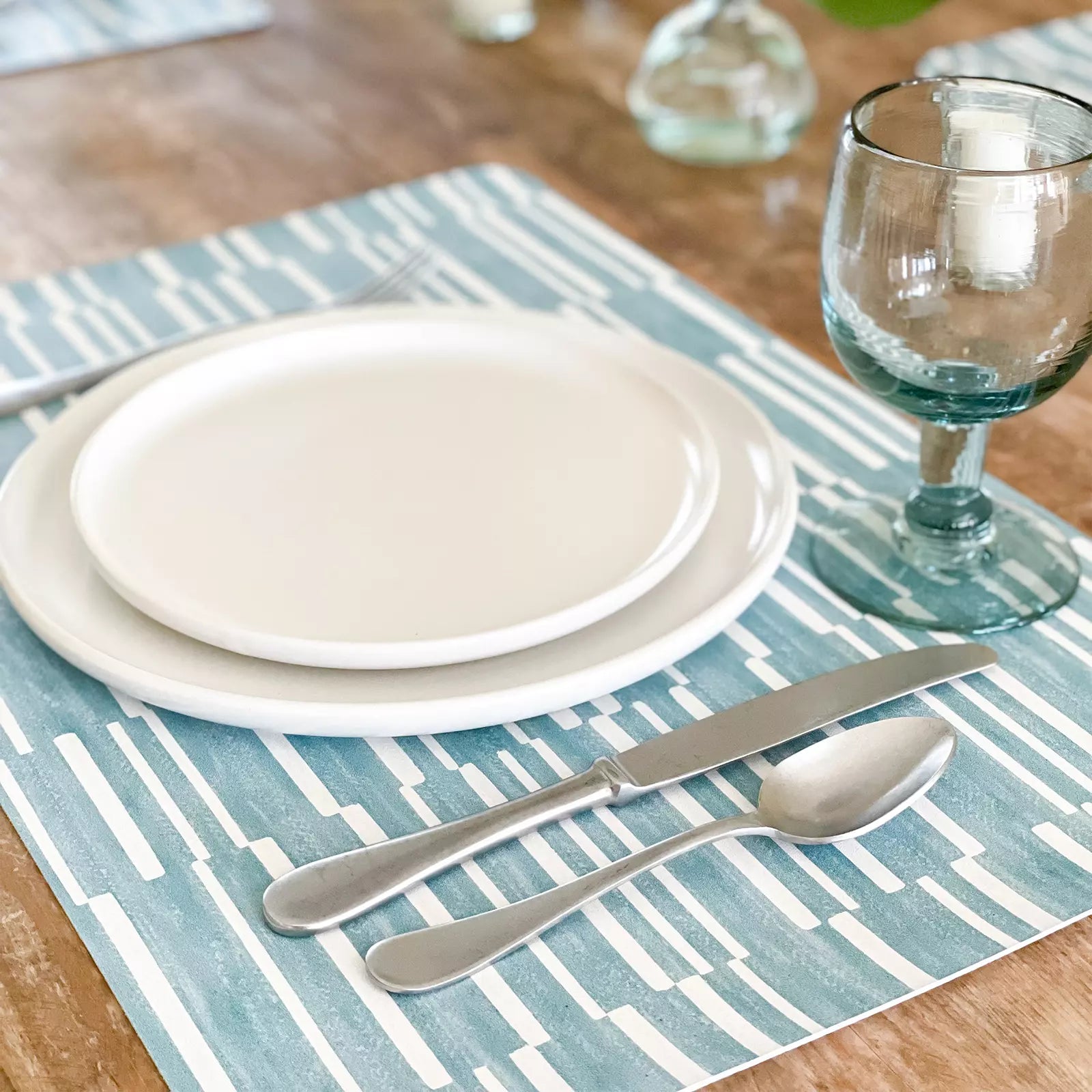 Nara Turquoise Blue Striped place mat at table setting with plate, napkin and silverware