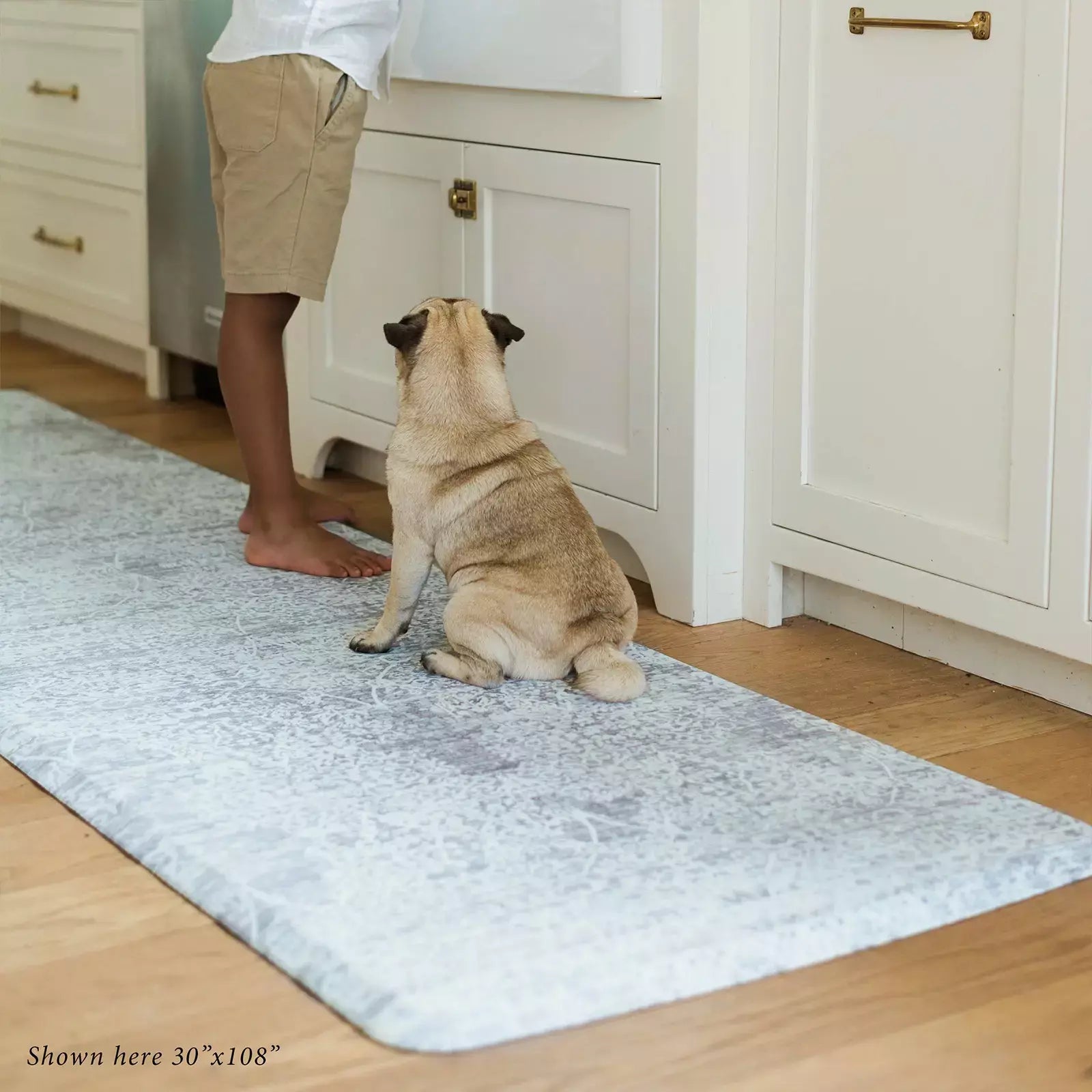 Gray neutral boho print kitchen mat with little boy and pug in kitchen shown in size 30x108
