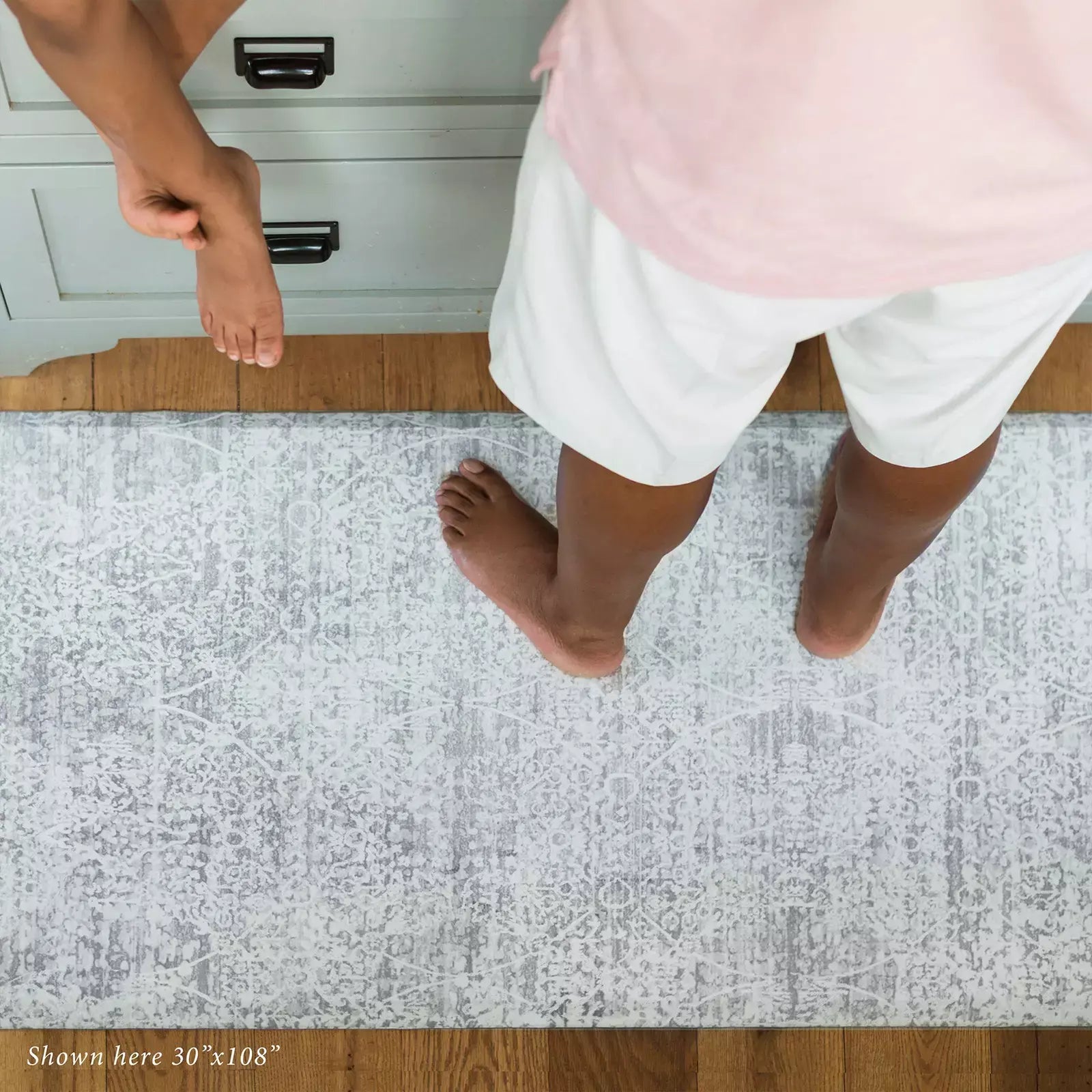 Gray neutral boho print kitchen mat with man and child in kitchen shown in size 30x108