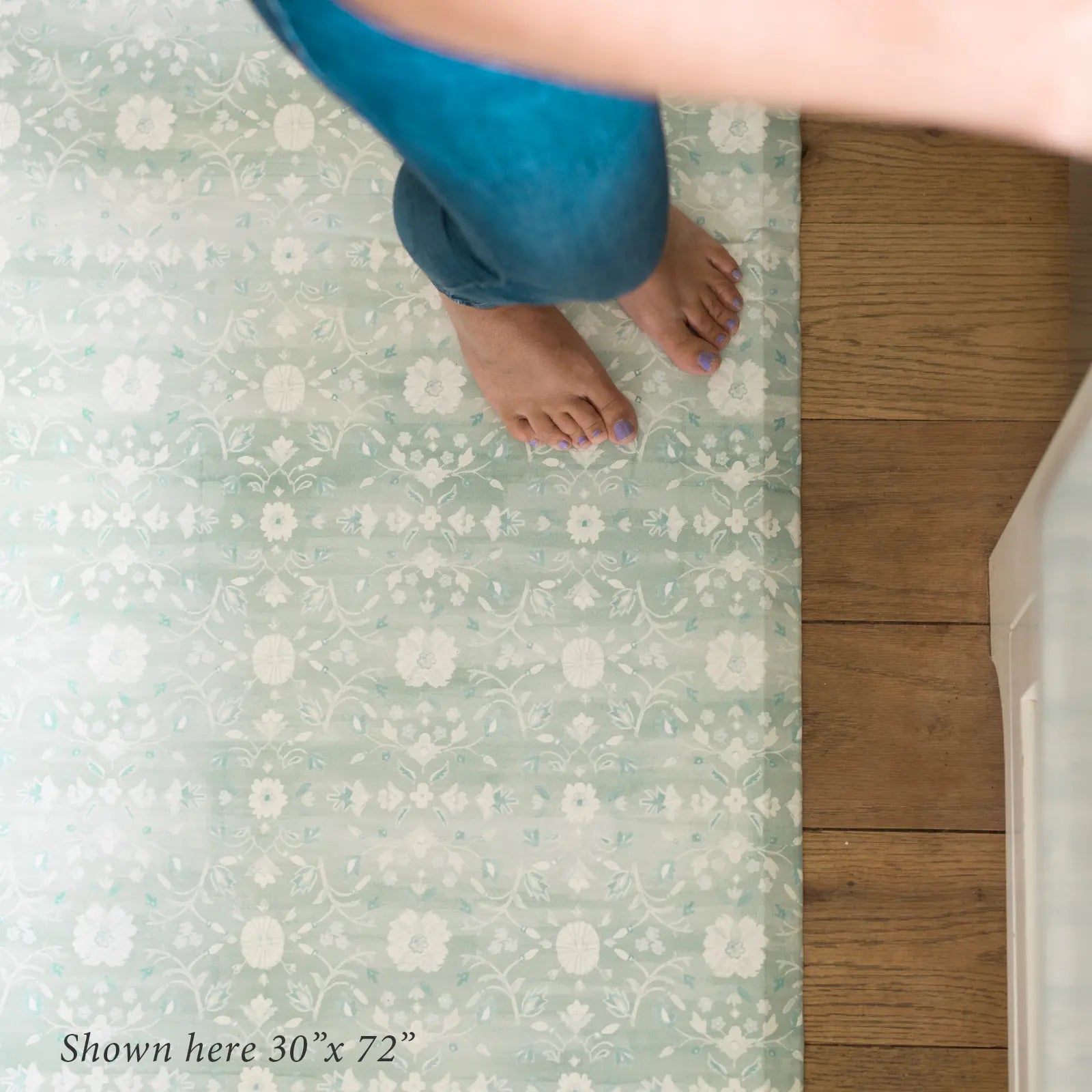 Nama standing mat Gemma white sage green floral shown from above with womans feet in size size 30x72