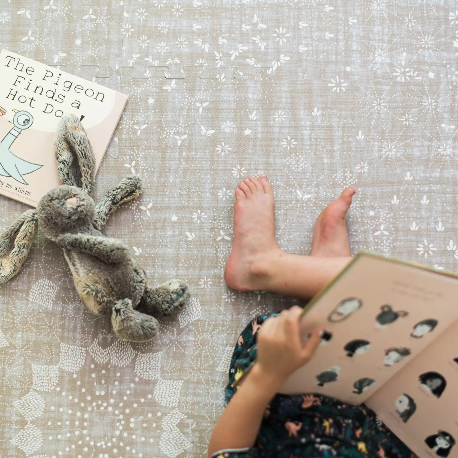 Sand Castle beige play mat shown from above with kid reading