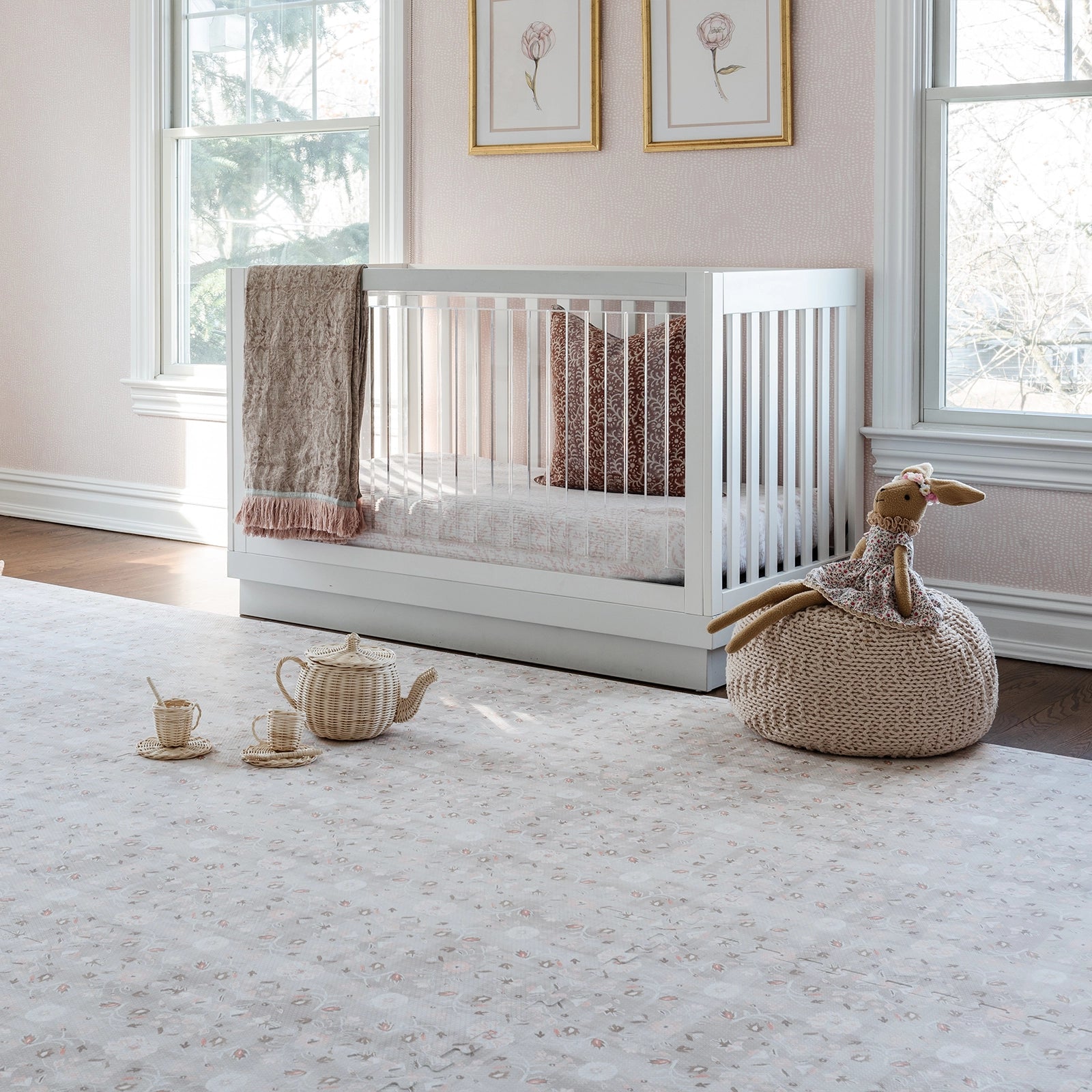 Linen beige and light pink floral baby play mat, shown in nursery with crib, plush toys, and tea set. 