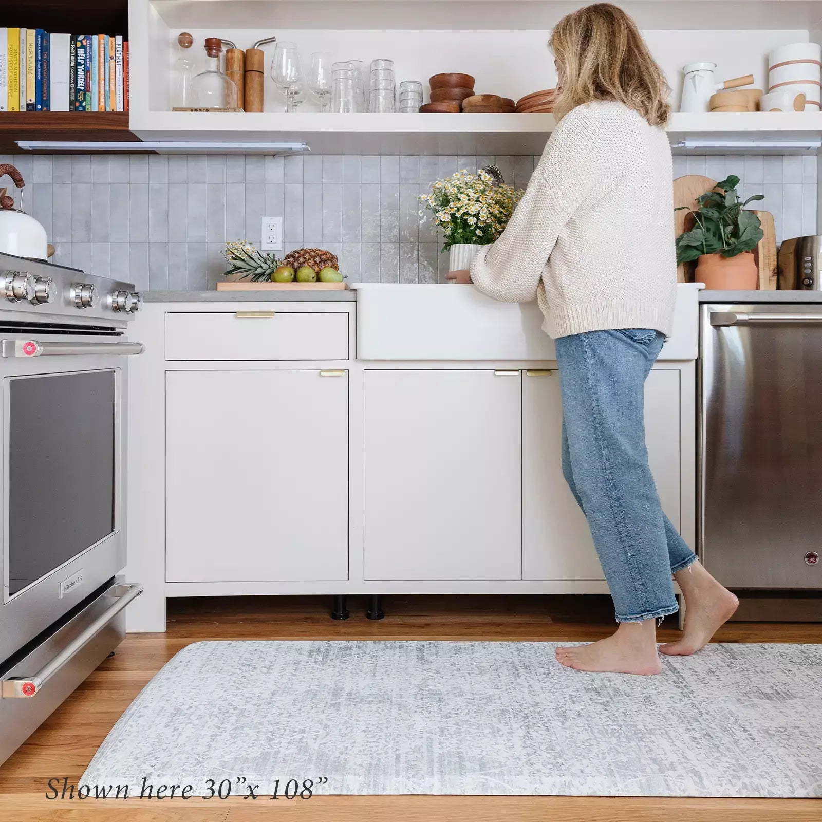 Gray neutral boho print kitchen mat with woman in kitchen shown in size 30x108