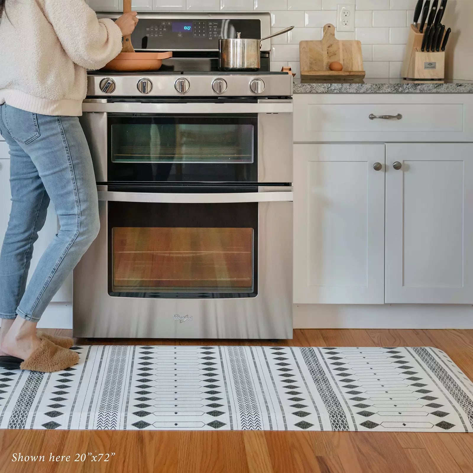 Nordique Slate Black and White Boho Nordic Print Standing Mat in kitchen with woman cooking at stove