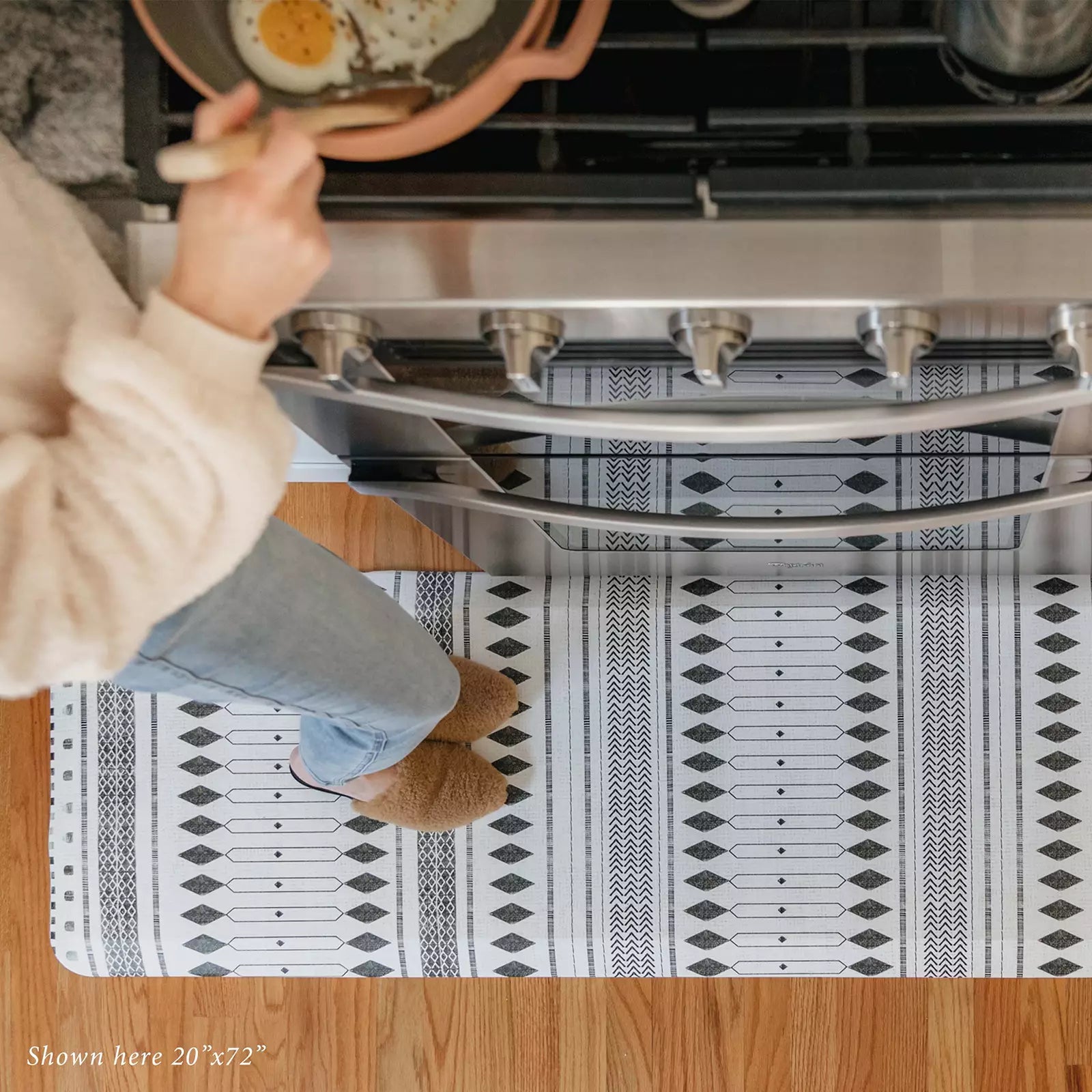 Nordique Slate Black and White Boho Nordic Print Standing Mat in kitchen with woman cooking at stove pictured from above