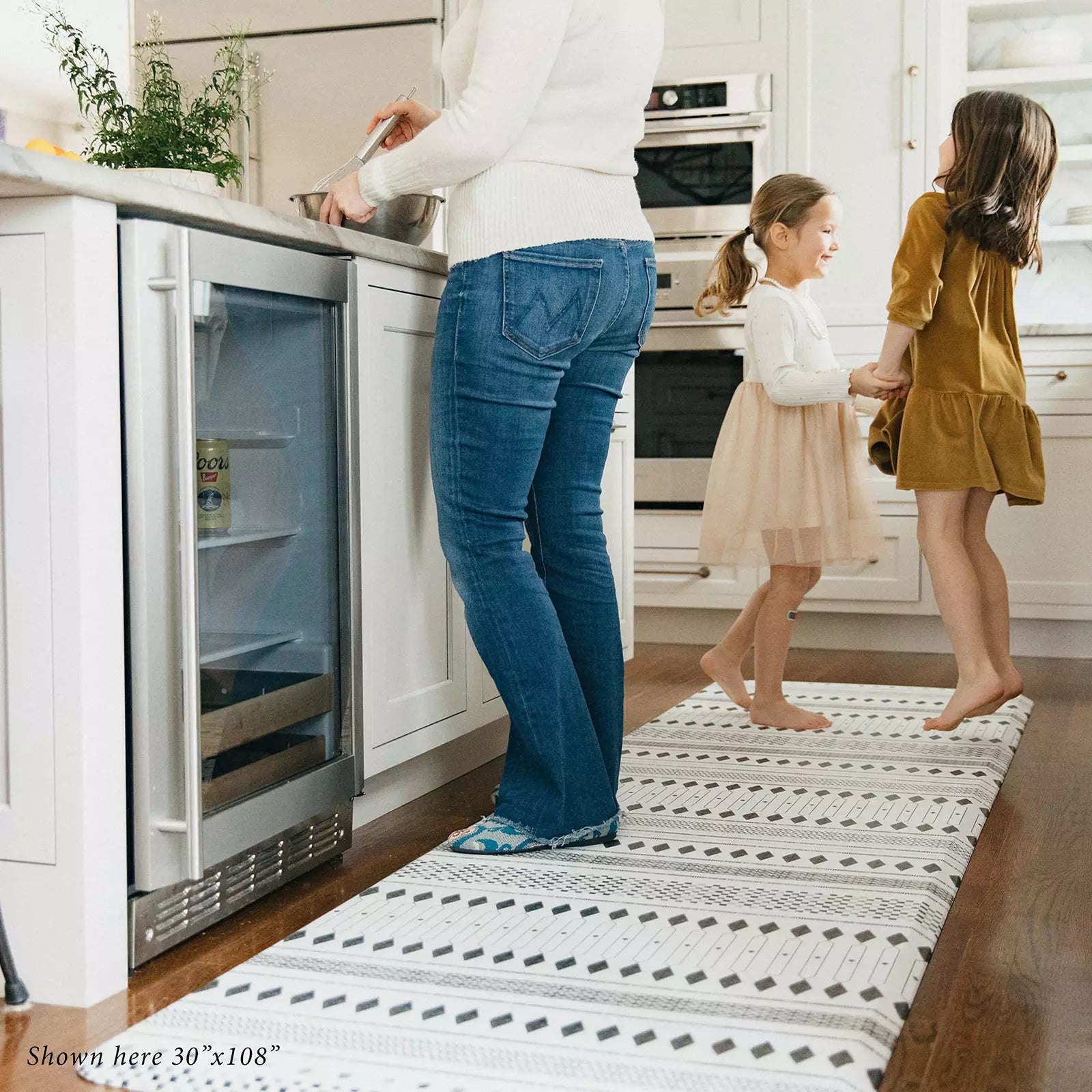 Nordique Slate Black and White Boho Nordic Print Standing Mat in kitchen with woman cooking and kids playing